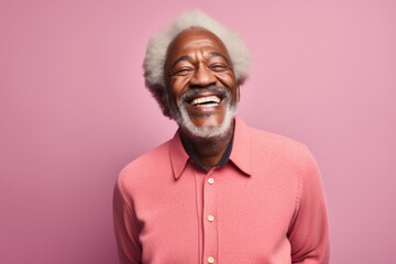 Portrait of a cheerful afro-american man in his 60s dressed in a warm wool sweater against a solid...
