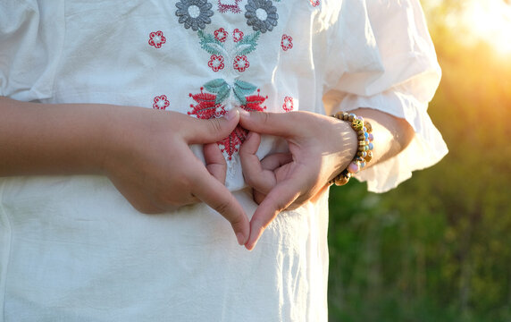 Woman on a white dress outdoor, doing meditation yoga mudra of hands, yoni symbol. female adi shakti hand gesture. spiritual, tantric practice, meditation. female energy, health concept.