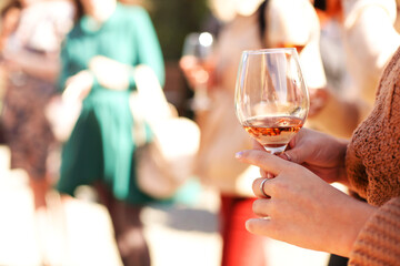 Unrecognizable female drinking wine in yard