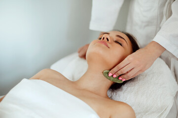 Fototapeta na wymiar Face massage or beauty treatment in spa salon