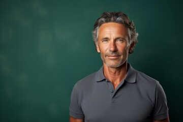 Obraz premium Portrait of a cheerful man in his 50s wearing a breathable golf polo against a bare concrete or plaster wall. AI Generation