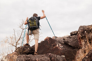 Healthy male successfully hiking walking to the top of mountain in holiday autumn alone, backpack tourist man happy exercise outdoors adventure trip traveling lifestyle, business achievement concept