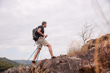 Healthy male successfully hiking walking to the top of mountain in holiday autumn alone, backpack...