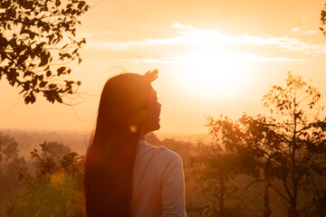Medium shot Asian female standing against sunset in golden hour on Autumn vacation day, young...