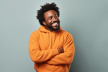 Obraz premium Portrait of a cheerful afro-american man in his 40s dressed in a comfy fleece pullover against a bare monochromatic room. AI Generation