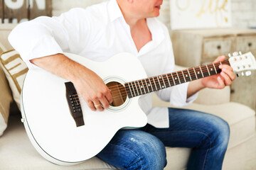 Crop man playing acoustic guitar