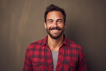 Portrait of a smiling man in his 30s dressed in a relaxed flannel shirt against a plain cyclorama studio wall. AI Generation