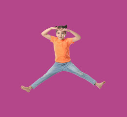 Fototapeta na wymiar Happy cute girl jumping on purple background