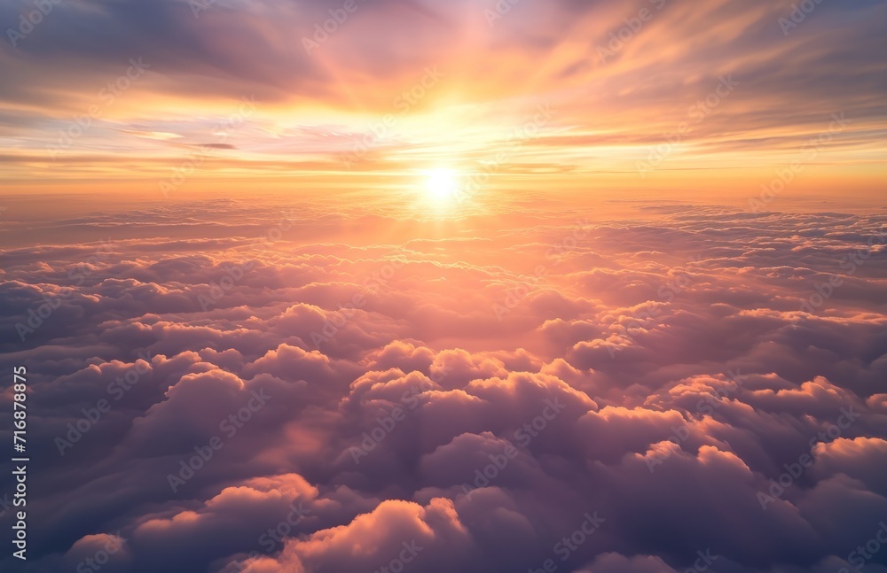 Wall mural the sun is setting over the clouds in the sky as seen from the window of an airplane in the sky abov