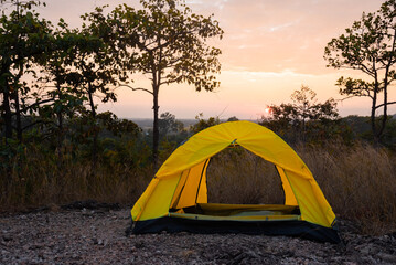 Young multiethnic couple man and Asian woman sitting in camping tent enjoy serene dusk sunset with happy free time relaxation together bonding relationship, couple valentines outdoor in nature trip