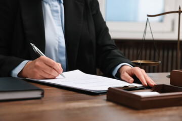 Lawyer working at wooden table in office, closeup - obrazy, fototapety, plakaty