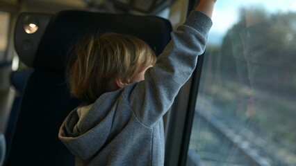 Child Playing with Train Blinds on European High-Speed Journey. Little boy passenger closes shades