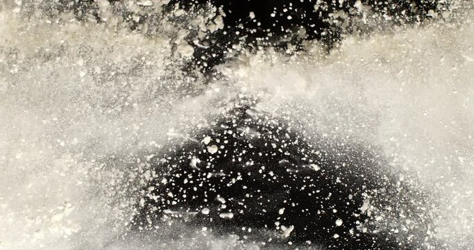 Super slow motion macro of flying baking wheat flour powder particles explosion isolated on black background at 1000 fps.