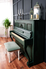 a dark green piano with a light chair against a dark blue wall. a ready-made decoration for a...