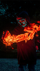 Burning hands with neon mask. Awesome and epic photo of a 10 year old holding fire with his bare...