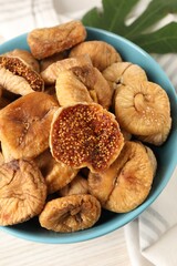 Bowl with tasty dried figs on white wooden table, above view
