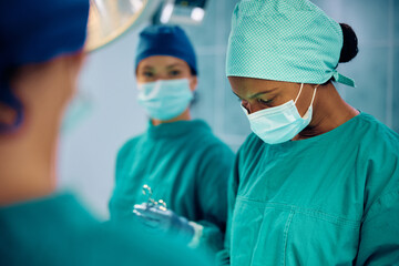 Fototapeta na wymiar Black female doctor performing surgery in operating room.