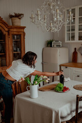Beautiful girl with dark hair in the kitchen with wine and food