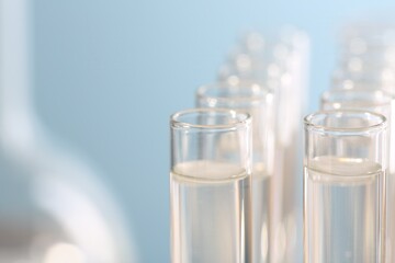 Laboratory analysis. Many glass test tubes on blurred background, closeup and space for text