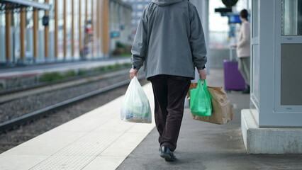 Elderly Man with Groceries walking in train platform - Daily Routine - obrazy, fototapety, plakaty