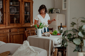 Beautiful girl with dark hair in the kitchen with wine and food