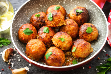 Meatballs in tomato sauce in the skillet at dark table. Close up image.