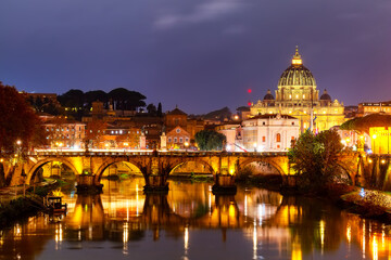 Beautiful vibrant night image of St. Peter's Basilica, Ponte Sant Angelo and Tiber River at dusk in...