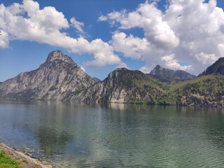 Mountain lake in Austria. Traunsee. Altmunster. Crystal clean water. Summer day, blue sky. Alps. Lake coastline. Rocks. Relaxing view. Mountain lake river.