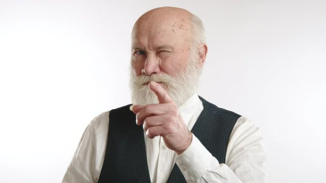Charming elderly man with a white beard giving a playful wink and a warm smile, clad in a smart vest, against a white backdrop. Camera 8K RAW. 