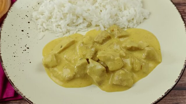 viande cuisin&eacute; au curry et lait de coco et riz blanc dans une assiette
