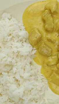 viande cuisin&eacute; au curry et lait de coco et riz blanc dans une assiette