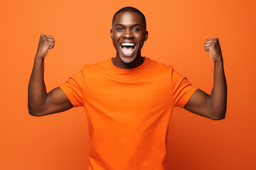 Young smiling happy overjoyed cool fun excited African American man he wearing t-shirt casual clothes looking camera spreading hands isolated on orange red color background