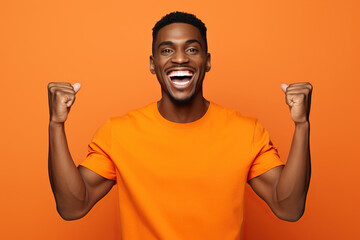 Young smiling happy overjoyed cool fun excited African American man he wearing t-shirt casual clothes looking camera spreading hands isolated on orange red color background