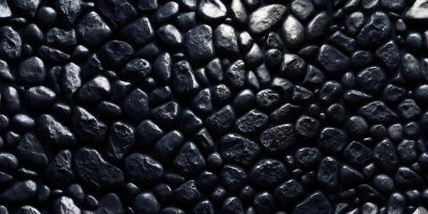 A background of densely spaced black stones illuminated by white light. Beautiful background.