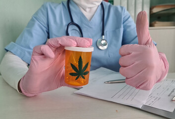 General practitioner holding a jar of CBD oil pills in hand showing thumbs up