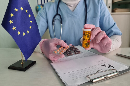 Therapist holding capsules in front of the wavy national flag of Europe