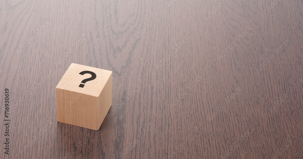 Poster one wooden block with question mark over a brown background with copy space