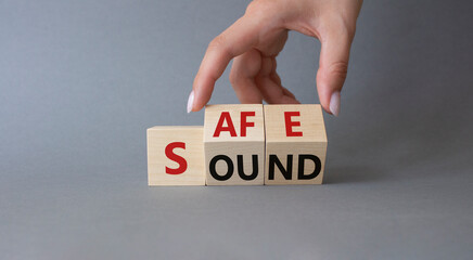 Safe and Sound symbol. Businessman hand Turns cubes with words Safe and Sound. Beautiful grey...