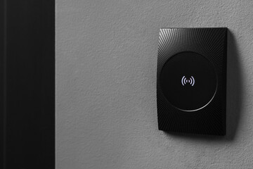 Magnetic door lock on grey textured wall, space for text. Home security