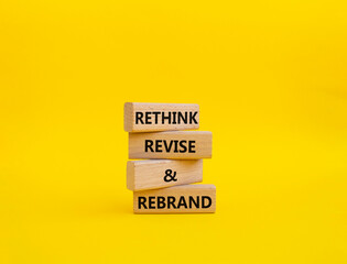 Rethink Revise and Rebrand symbol. Wooden blocks with words Rethink Revise and Rebrand. Beautiful yellow background. Business and Rethink Revise and Rebrand concept. Copy space.