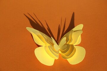 Yellow decorative paper butterflies on orange background