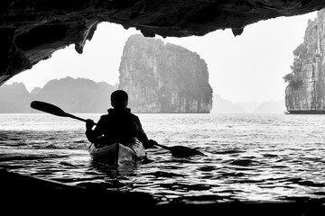 Silhouette of a man kayaking in a cave in Ha Long Bay, Vietnam