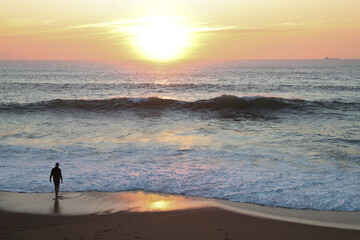 Winsurfer on the beach at sunset