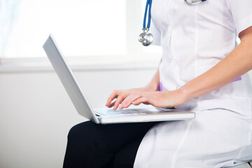 Naklejka premium Female doctor working with laptop