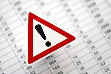 Small exclamation sign lies on business calculations close up. Attention to errors and mistakes in...