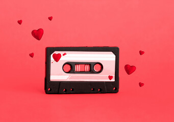 Cute red analog cassette on red background with reds hearts flying around.