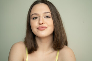 portrait of a young beautiful woman with dark short hair looking at the camera in yellow lingerie