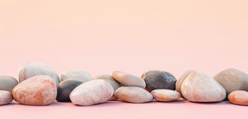 A variety of smooth stones on a soft peach orange surface.