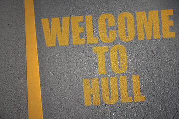 asphalt road with text welcome to Hull near yellow line.
