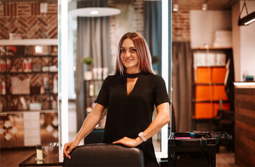 Fototapeta premium Portrait of a young and pretty hairdresser